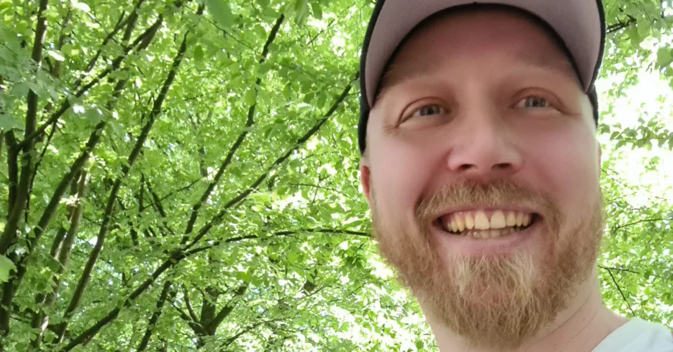 Porträt von Christoph Bußinger, Autor und Gründer, mit Schildmütze und rotem Rucksack – bereit für neue Projekte.